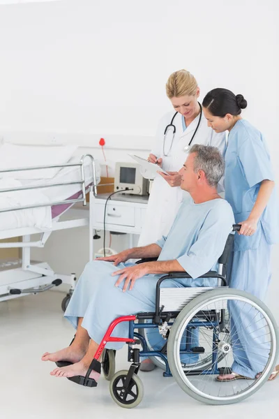 Doctor talking to a patient in wheelchair at hospital — Stock Photo, Image