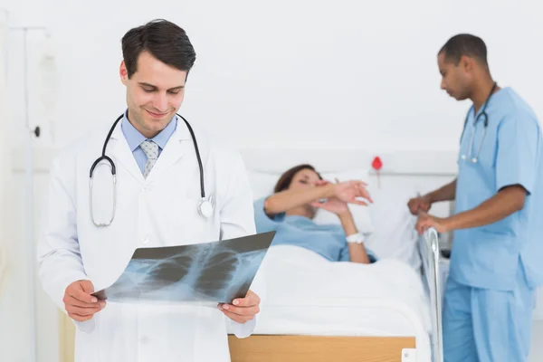 Arzt untersucht Röntgenbild mit Patient im Krankenhaus — Stockfoto
