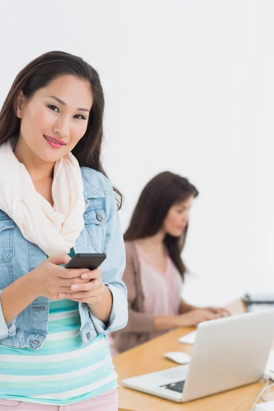 Sorridente casuale donna messaggi di testo in ufficio — Foto Stock