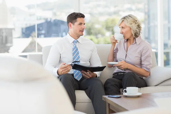 Slimme zakenman en zijn secretaresse met dagboek en thee beker — Stockfoto