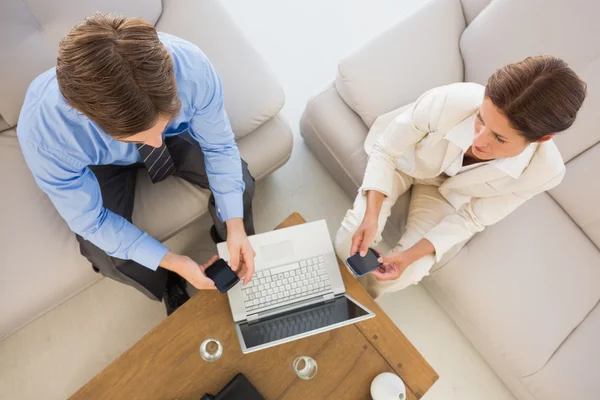 Zakelijke team werken samen op de Bank met behulp van hun smartphones — Stockfoto