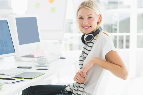 Mujer casual con auriculares en el escritorio de la computadora en la oficina —  Fotos de Stock