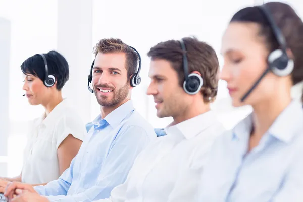 Business colleagues with headsets in a row — Stock Photo, Image