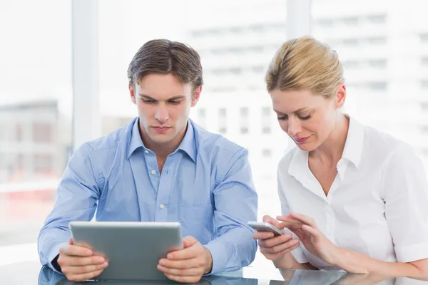 Επιχειρηματίας και γυναίκα χρησιμοποιώντας ψηφιακή δισκίο και κινητό τηλέφωνο στο ΔΗΜΟ — Φωτογραφία Αρχείου