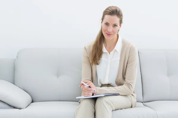 Smiling female financial adviser sitting on sofa — Stock Photo, Image