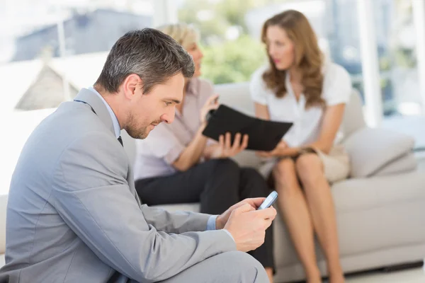 Geschäftstexte mit Kollegen, die zu Hause sitzen — Stockfoto