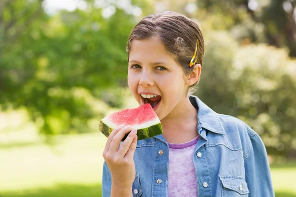 Leende ung flicka äter vattenmelon i park — Stockfoto