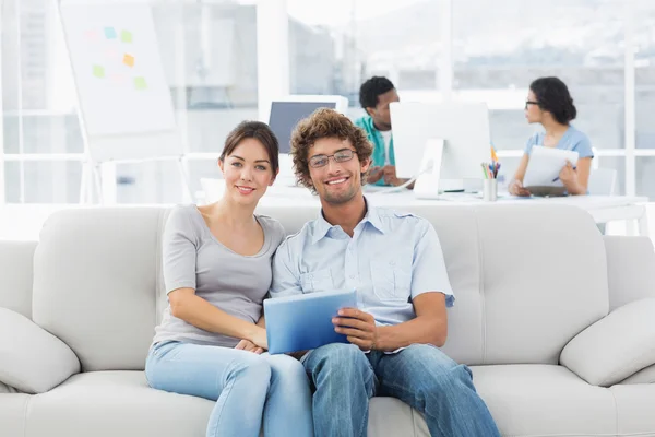 Couple using digital tablet with colleagues at creative office — Stock Photo, Image