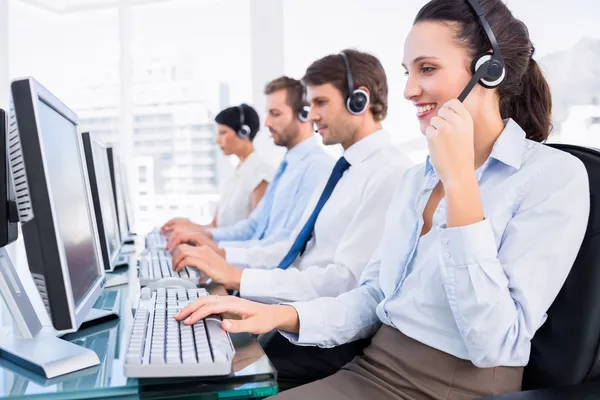 Compañeros de negocios con auriculares usando computadoras — Foto de Stock