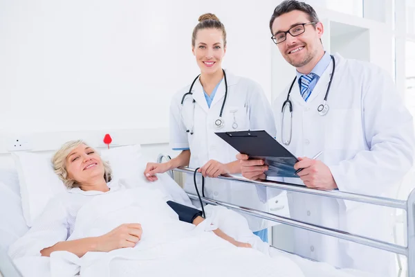 Doctors visiting a female patient in hospital — Stock Photo, Image