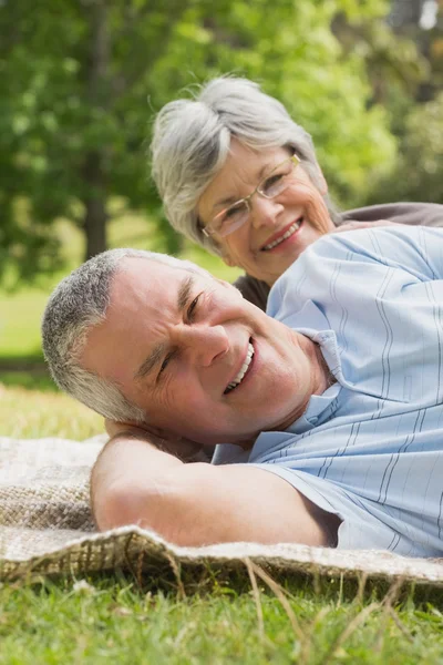 Close-up portrait of a senior couple lying at park — Stock Photo, Image