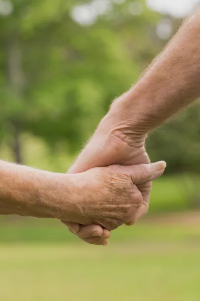 Пожилая пара, держащаяся за руки — стоковое фото