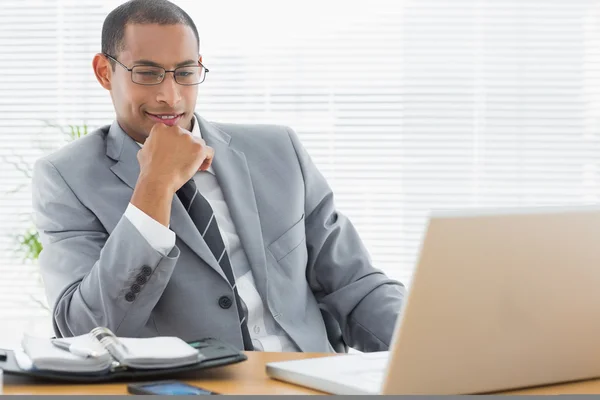 Бизнесмен, сидящий за рабочим столом с ноутбуком — стоковое фото