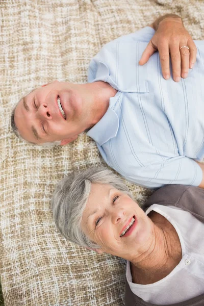 Smiling relaxed senior couple lying in park — Stock Photo, Image