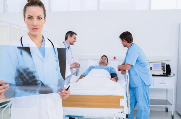 Dokter bedrijf x-ray met collega's en patiënt in het ziekenhuis — Stockfoto