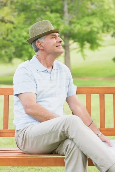 Starszy mężczyzna siedzi na ławce w parku — Zdjęcie stockowe