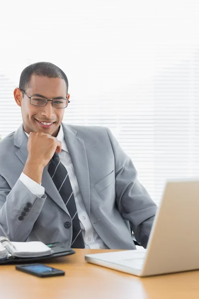 Confident businessman with laptop at office desk — Stock Photo, Image