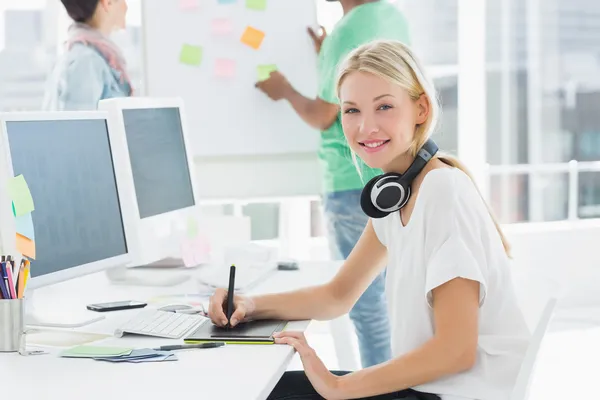 Artist drawing something on graphic tablet with colleagues behin — Stock Photo, Image