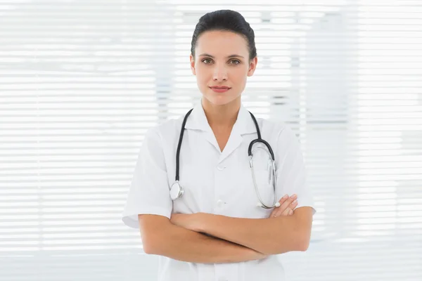 Beautiful female doctor standing with arms crossed — Stock Photo, Image