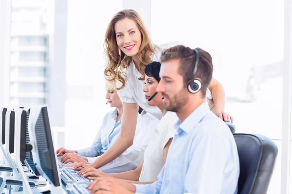 Administrador y ejecutivos con auriculares usando computadoras — Foto de Stock