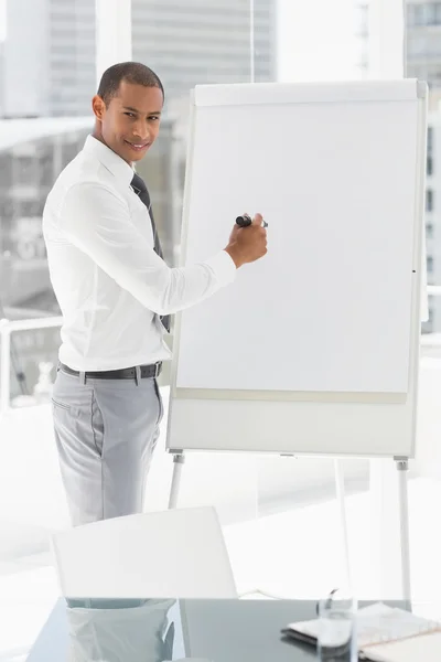 Jeune homme d'affaires souriant se présentant au tableau blanc avec marqueur — Photo