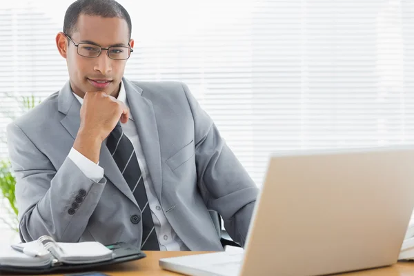 Säker affärsman med laptop på skrivbord — Stockfoto