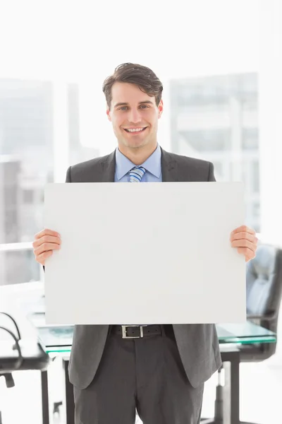 Handsome smiling businessman holding placard — Stock Photo, Image