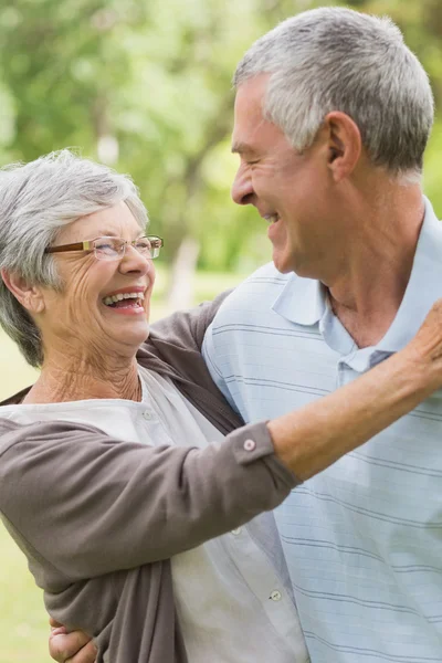 Mulher sênior feliz abraçando o homem no parque — Fotografia de Stock