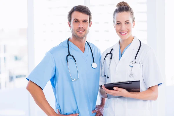 Male surgeon and female doctor with medical reports — Stock Photo, Image