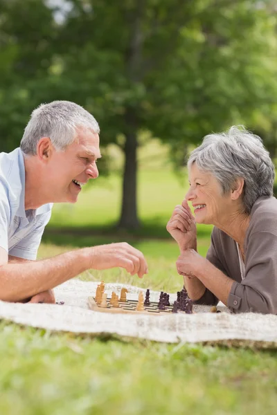 Glückliches Seniorenpaar spielt Schach im Park — Stockfoto