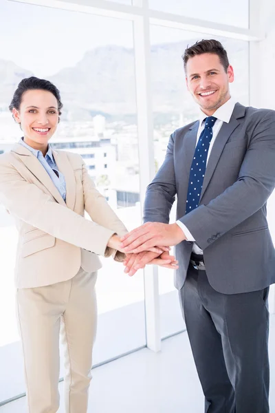 Compañeros de negocios alegres que unen sus manos — Foto de Stock