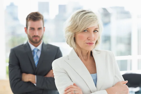 Mature businesswoman and young man with arms crossed — Stock Photo, Image