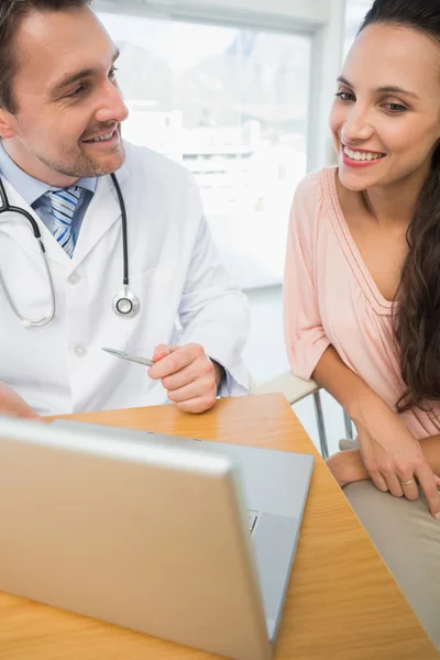 Male doctor showing something on laptop to patient — Stock Photo, Image