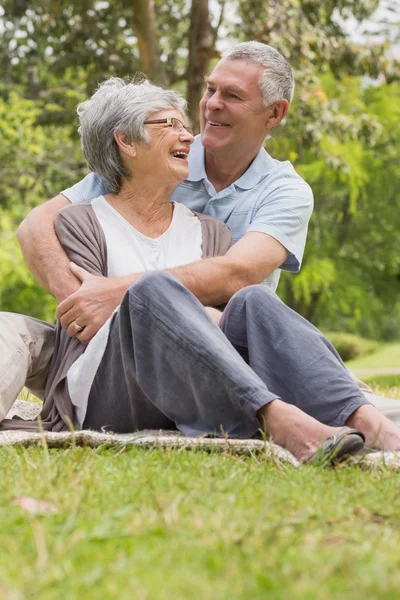 Senior man embracing woman from behind at park — Stock Photo, Image