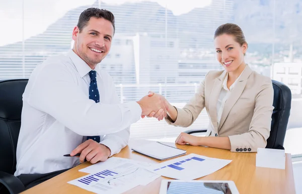 Compañeros vestidos con inteligencia estrechando la mano en una reunión de negocios — Foto de Stock