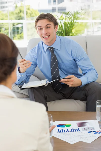 Happy businessman scheduling with colleague sitting on sofa — Stock Photo, Image