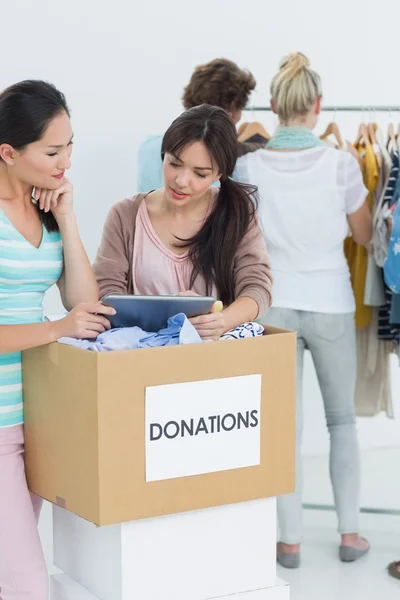 Personas con donación de ropa mientras usan tableta digital — Foto de Stock