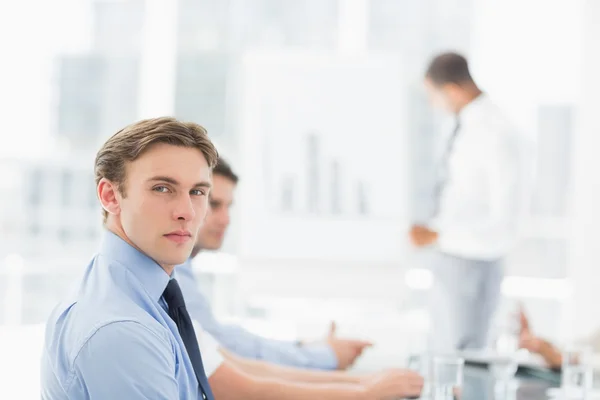 Seriöser Geschäftsmann blickt während eines Meetings in die Kamera — Stockfoto