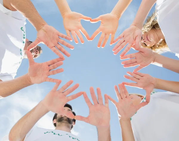 Voluntarios con las manos juntas contra el cielo azul — Foto de Stock