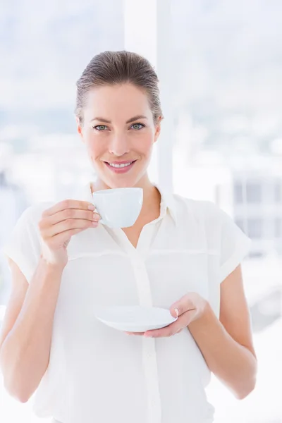 Çay bardağı ile gülümseyen genç iş kadını — Stok fotoğraf