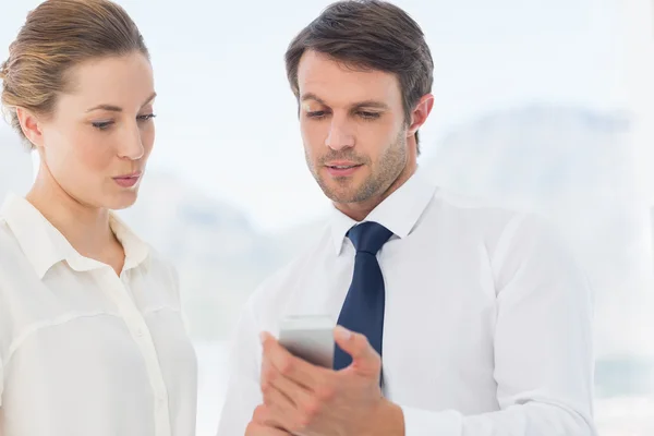 Smartly dressed colleagues looking at mobile phone — Stock Photo, Image