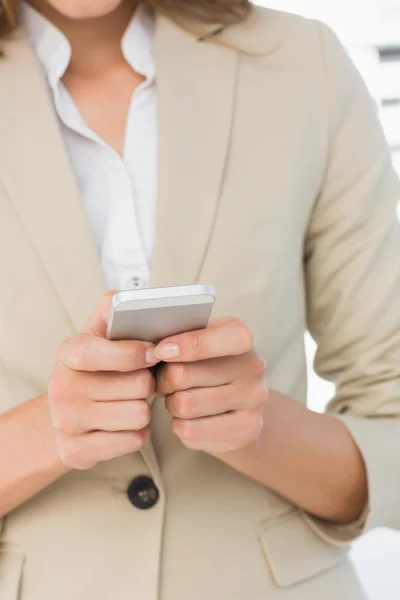 Mid section of a businesswoman text messaging — Stock Photo, Image