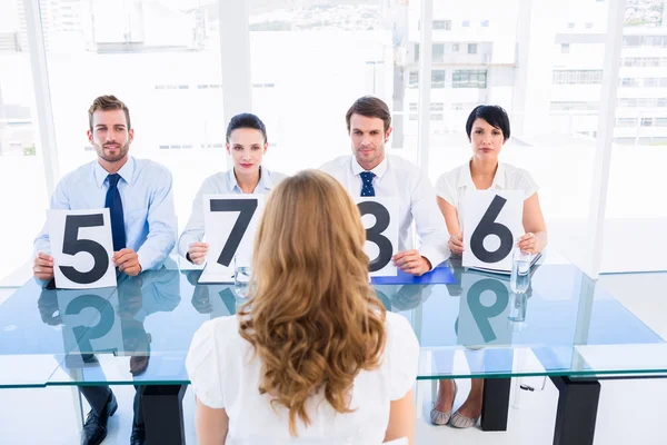 Grupo de jueces del panel con signos de puntuación delante de la mujer — Foto de Stock