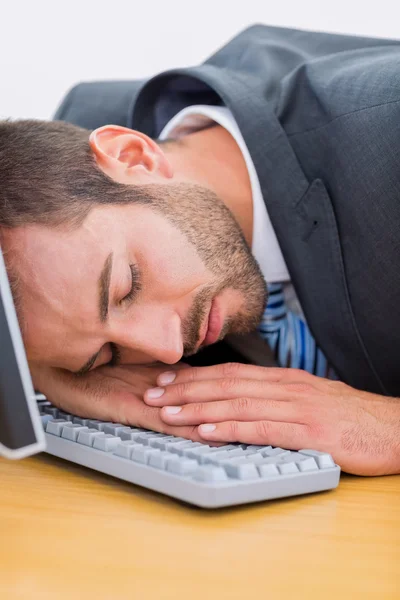Biznesmen odpoczynku z głową na klawiaturze na biurko — Zdjęcie stockowe