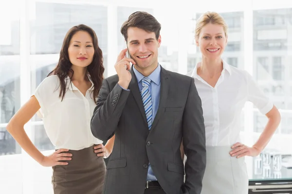 Glücklicher Geschäftsmann am Telefon vor seinem Team — Stockfoto