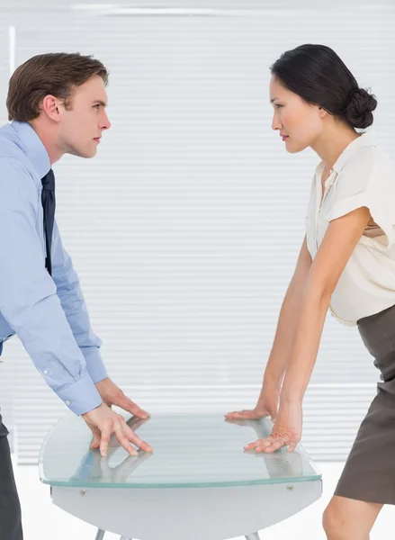 Business couple looking at each other with palms at desk — Stock Photo, Image