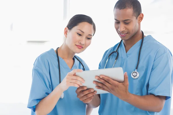 Surgeons looking at digital tablet in hospital — Stock Photo, Image