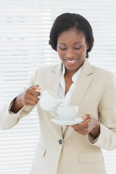 Elegante Glimlachende zakenvrouw met thee beker in office — Stockfoto