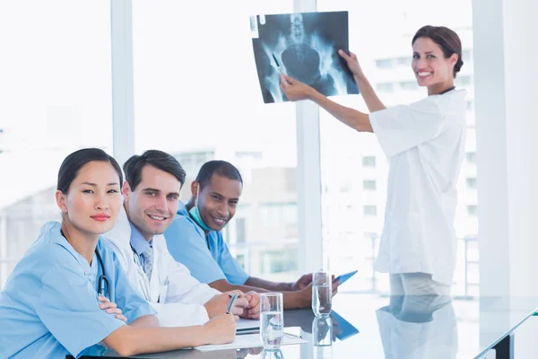 Médica mulher explicando raio-x para sua equipe — Fotografia de Stock