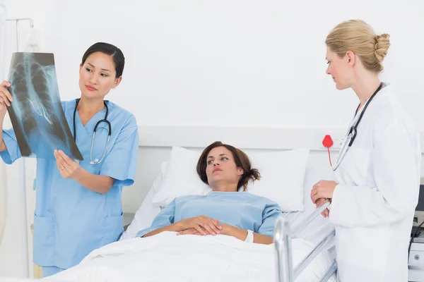 Ärzte untersuchen Röntgenbild mit Patient im Krankenhaus — Stockfoto